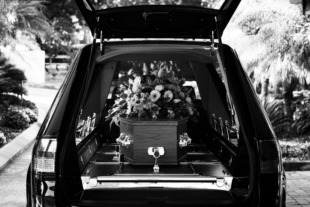 A casket and floral tribute in a funeral hearse
