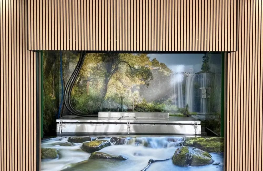 The water cremation chamber behind glass, framed in timber